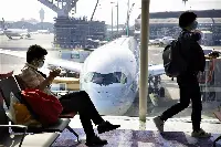 Mascherine anticontagio da Covid-19 in aeroporto, in attesa di salire sull'aereo