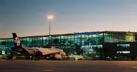 Vista notturna dell'aeroporto di Brisbane con un aereo di Air New Zeland