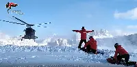 Elicottero in volo su una montagna e Carabinieri impegnati ad effettuare rilievi sulla neve per evitare incidenti provocati da valanghe